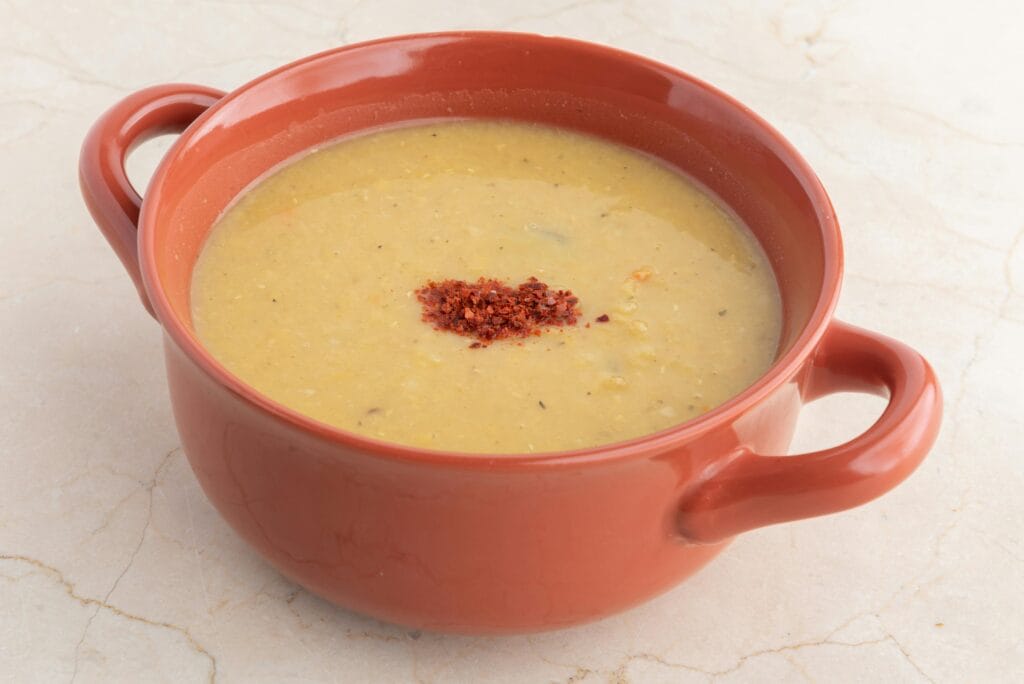Delicious homemade lentil soup in a terra cotta bowl, perfect for a comforting meal.