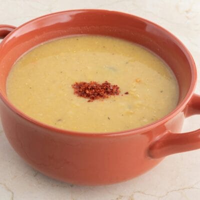 Delicious homemade lentil soup in a terra cotta bowl, perfect for a comforting meal.