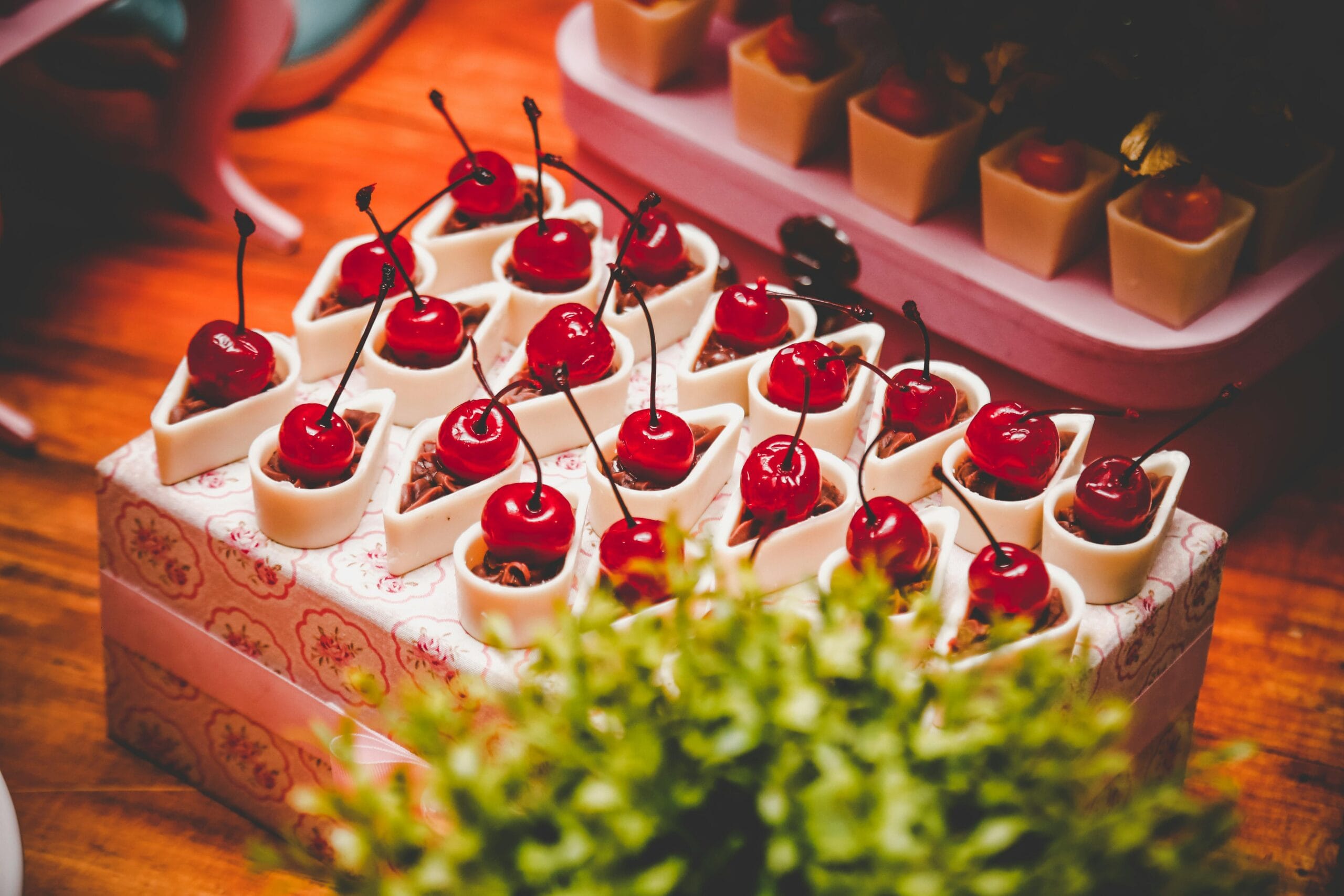 Close-up of cherry-topped desserts arranged on a decorative tray, perfect for indulgence and celebration.